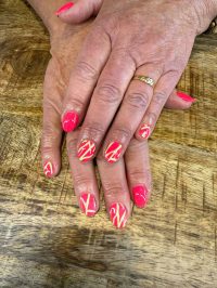Geverifieerde ALT tag: Mooie hand met kleurrijke, artistieke nagelkunst op een houten tafel.